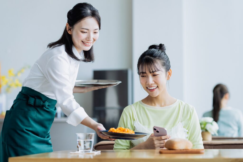 カフェで料理を配膳する若い女性