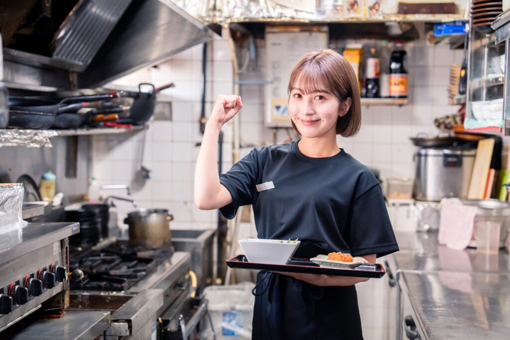 飲食店の厨房で働く若い女性のスタッフ