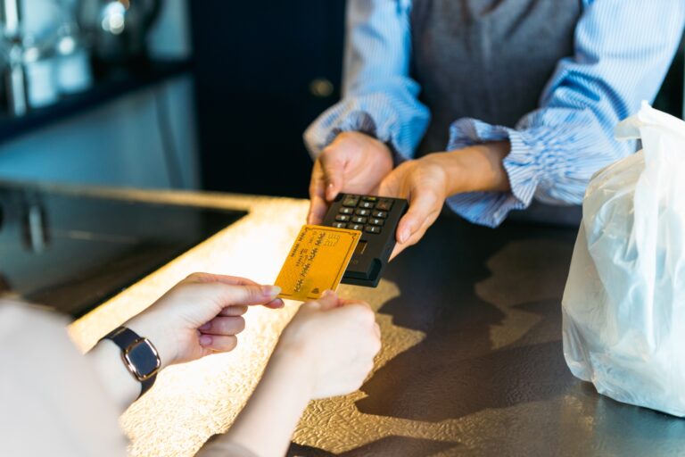 カフェでタッチ決済をする女性の手元