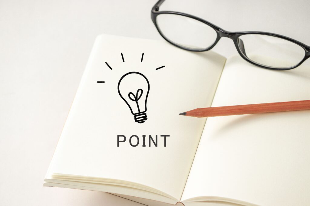 「POINT」と記載されたノートとメガネ。