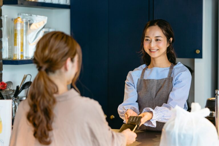 カフェでキャッシュレス決済をする女性（飲食店・テイクアウト）