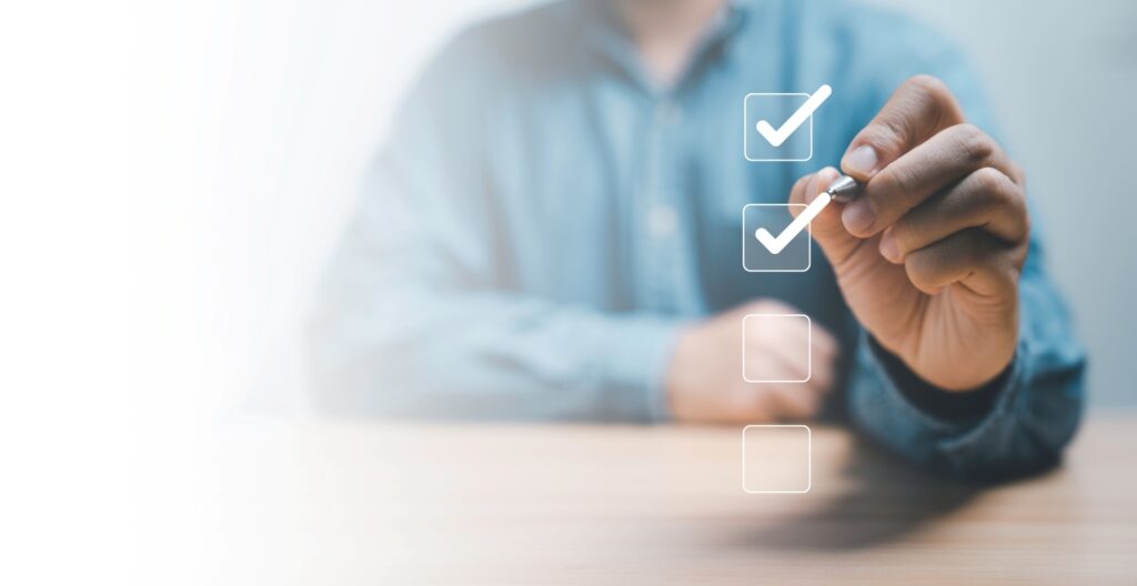 ペンを使用してサービスのチェックリストのチェックボックスに正しい記号（チェック）を入れるビジネスマン